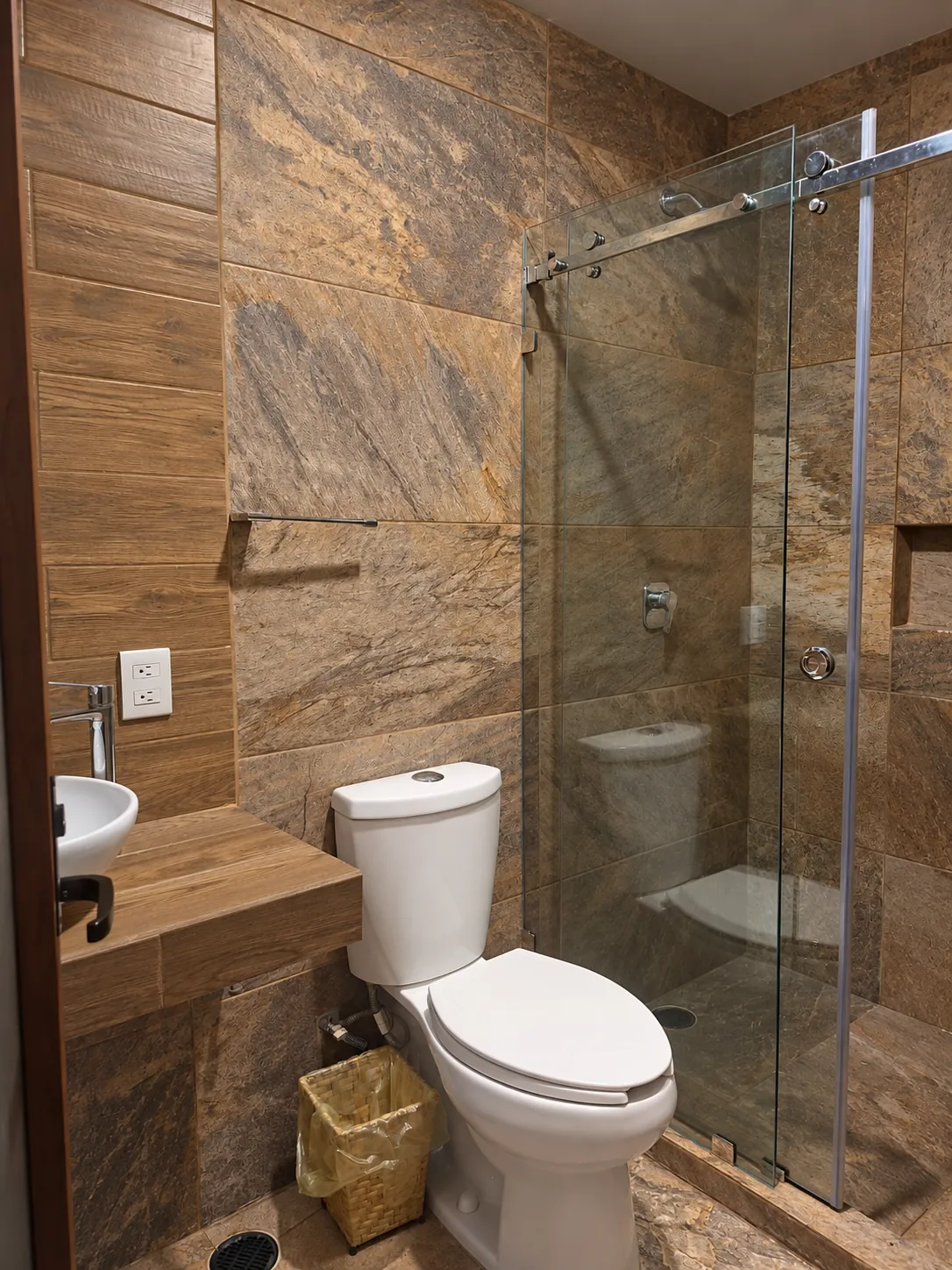 Baño con ducha de vidrio y tonos cálidos